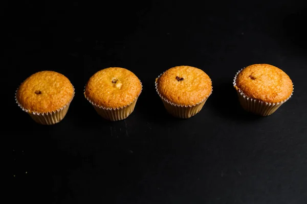 Cupcakes em um fundo preto. Cozimento — Fotografia de Stock