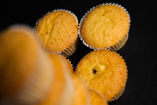 Cupcakes em um fundo preto. Cozimento — Fotografia de Stock