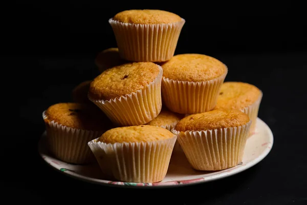 Cupcakes em um fundo preto. Cozimento — Fotografia de Stock