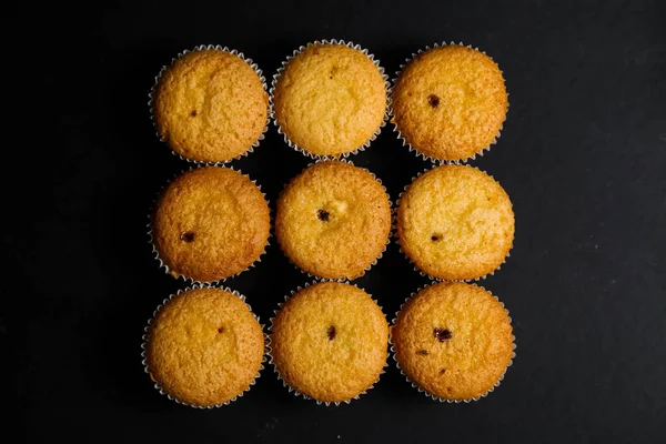 Cupcakes em um fundo preto. Cozimento — Fotografia de Stock