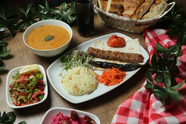 Turco Adana Kebab con verduras frescas en pan plano Vista superior, laico plano — Foto de Stock