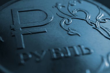 Yazının çevirisi: Ruble. Rusya 'nın ulusal para biriminin sembolü veya işaretiyle Rus 1 ruble sikkesi. Koyu mavi arka plan ya da duvar kağıdı. Renkli ekonomik zemin