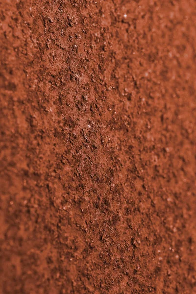 Dark ocher background or wallpaper. Vertical textured backdrop. Rough matte surface. A toned shot of rusty iron. Rich, deep color. Macro