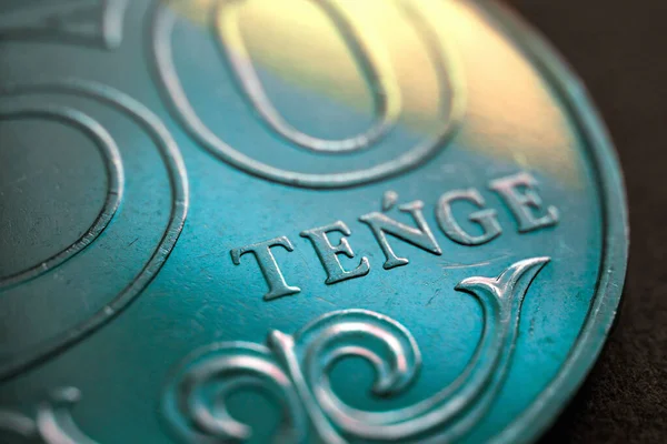Yazının çevirisi: tenge. Kazak madeni parasının bir parçası 50 tenge içinde. Latince 'de para biriminin adı. İllüstrasyon ulusal bayrağın renkleriyle renklendirilmiştir. Kazakistan Ekonomisi