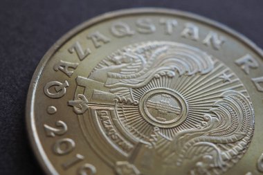 Yazıtın çevirisi: Kazakistan. Kazak 50 tenge madeni para ülke amblemi ve shanyrak odaklanın. Ekonomi temalı bir arka plan ya da duvar kağıdı. Latin alfabesine geçiş. Makro