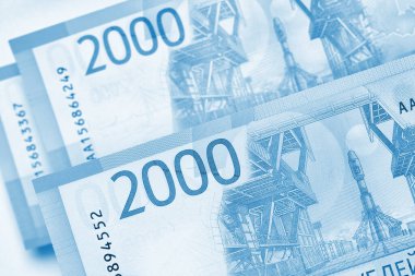 Rusya 'nın para, finans ve ekonomi konularında hafif bir geçmişi var. Mavi renkli arka plan. 2000 rublelik banknotlar. Tasarruf, mevduat, kredi, mikro krediler. Yukarıdan bak. Makro