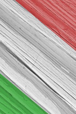 İtalya bayrağı kuru ahşap yüzeyde, yaşla çatladı. Açık soluk soluk boya. Dikey arkaplan, duvar kağıdı ya da İtalyan ulusal sembollü arka plan. Gölgelerle sert güneş ışığını yönlendir