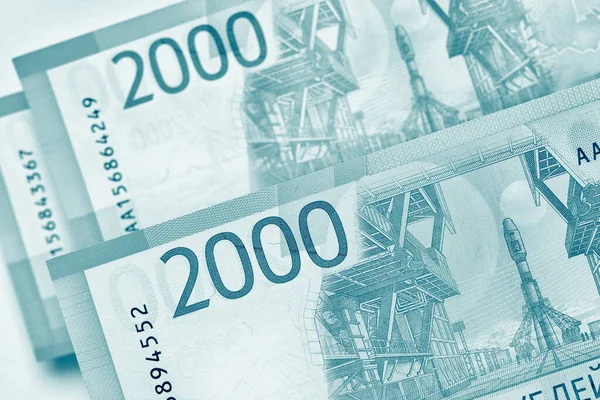 Rusya 'nın para, finans ve ekonomi konularında hafif bir geçmişi var. Mavi yeşil renkli arka plan. 2000 rublelik banknotlar kapanıyor. Bankacılık, tasarruf, depozito, kredi ve mikro kredi. Makro