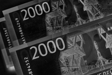 Rusya 'nın parası, finans ve ekonomisi hakkında karanlık bir illüstrasyon. Kabartma gibi görünen siyah-beyaz bir resim. 2000 rublelik banknotlar kapanıyor. Yukarıdan bak. Makro