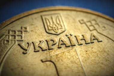 Yazının çevirisi: Ukrayna. 1 Hryvnia 'da Ukrayna madeni parasının bir parçası. Ekonomi ve kamu maliyesi teması üzerine yıllanmış gösterişli bir illüstrasyon. Gözetleme. Ülkenin ismine odaklan.