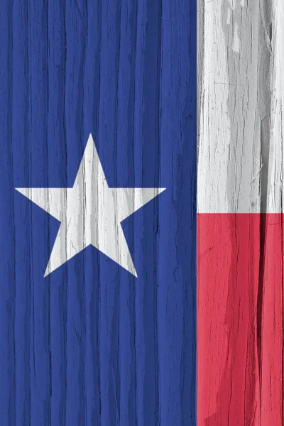 Texas state flag on dry wooden surface. Vertical bright background, wallpaper or backdrop made of old wood. The symbol of one of the American states. Lone Star State. Solar lighting with hard shadows