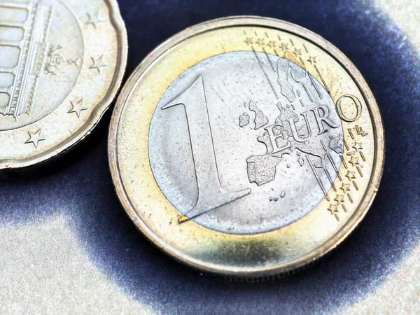 Two euro coins. The focus is on the inscription with the name of the Euro Zone currency on the 1 euro coin. Close-up. Illustration about the economy, money and finance of the European Union. Macro