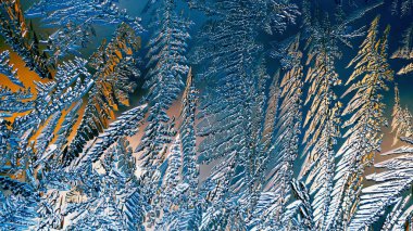 Fantezi buz kristalleri. Ateşli kış duvar kâğıdı. Pencere camına buz çiziyorum. Sihirli fantastik bitkilerin yaprak ve gövdeleri. Akılda kalıcı soyut mavi ve turuncu arka plan. Makro