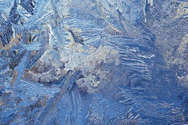 Fantezi buz kristalleri. Ateşli kış duvar kâğıdı. Pencere camına buz çiziyorum. Sihirli fantastik bitkilerin yaprak ve gövdeleri. Soyut mistik dantel arka plan. Makro