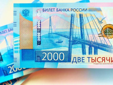 Yakın plan 2000 Ruble 'lik Rus banknotları. Banknotlarda Vladivostok şehrinde adaya bir köprü tasvir ediliyor. Rusya 'daki bankalar, mevduatlar, krediler, faizler ve mikro krediler hakkında gerçekçi çizimler. Makro