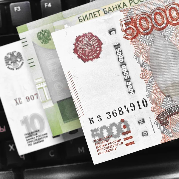 黒いコンピューターのキーボードの上にロシアのお金 ロシアでのリモートジョブとフリーランス 5000ルーブルなどの紙幣 正方形のイラスト マクロ — ストック写真