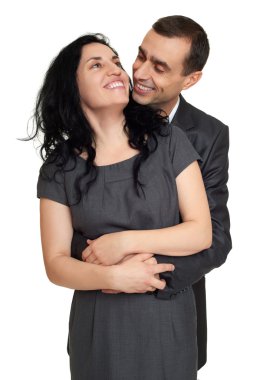 Çift kucaklama, beyaz stüdyo portre. Siyah takım elbise giymiş.