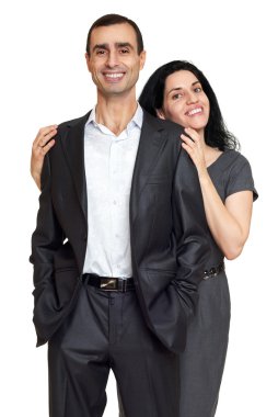 Çift kucaklama, beyaz stüdyo portre. Siyah takım elbise giymiş.