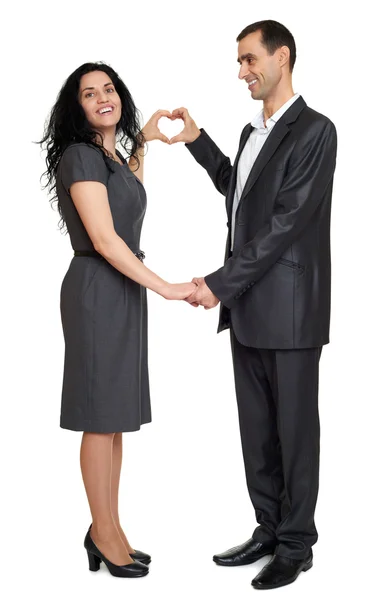 Happy couple dressed in strong classic dress, making heart shape from fingers, studio portrait on white — Stock Photo, Image