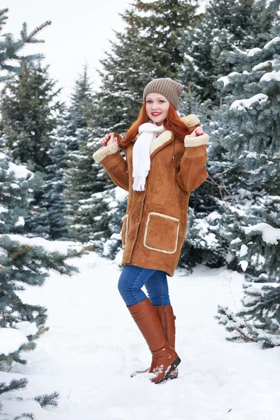 Chica posando en el parque de invierno en el día. Abeto con nieve. Pelirroja mujer longitud completa . — Foto de Stock