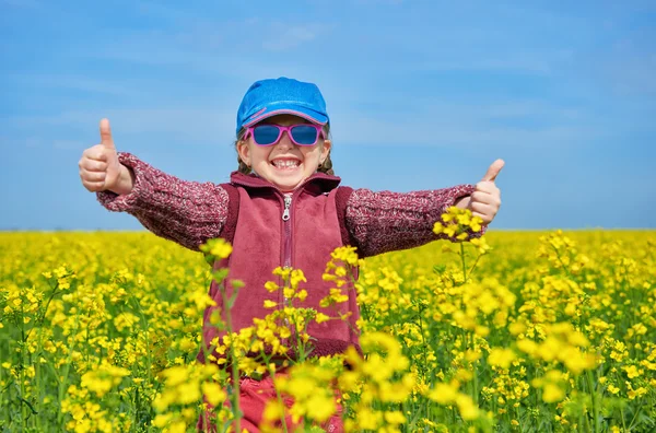 Meisje kind op koolzaad gebied met heldere gele bloemen, lente landschap — Stockfoto
