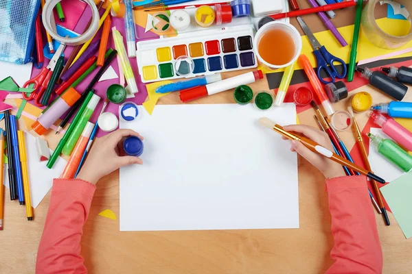 Kind zeichnet Draufsicht. Kunstwerk-Arbeitsplatz mit kreativen Accessoires. flache Laien-Kunstwerkzeuge zum Malen. — Stockfoto