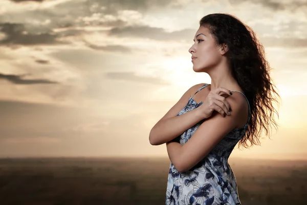 Girl portrait at sunset on evening sky background — Stock Photo, Image