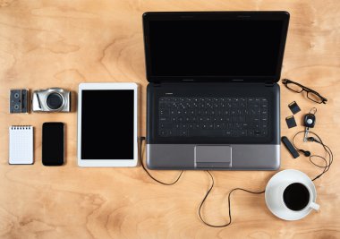 Düz kişisel ofis aksesuarları, laptop, dizüstü, kahve fincanı ve kamera ahşap arka plan, üstten görünüm üzerinde yatıyordu