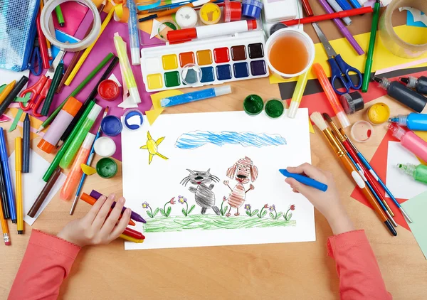 Child drawing cat and dog friends walk on grass, top view hands with pencil painting picture on paper, artwork workplace — Stock Photo, Image