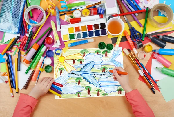 Airliner fly high above the earth, child drawing, top view hands with pencil painting picture on paper, artwork workplace — Stock Photo, Image