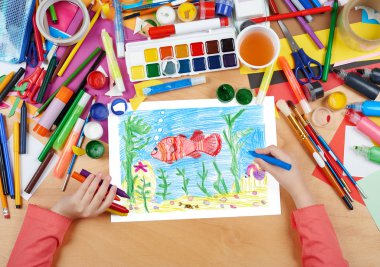 kırmızı balık suyun altında Yengeç dibinin üzerinde çizim çocuk, kalem resim resim kağıt, sanat işyeri ile üstten görünüm eller