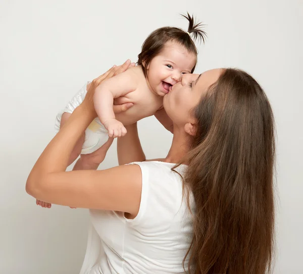 Mom throws up baby and kiss, play and having fun, parenting, happy family concept — Stock Photo, Image