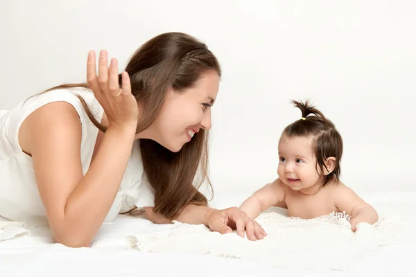 Retrato de la madre y el bebé yacen sobre una toalla blanca — Foto de Stock