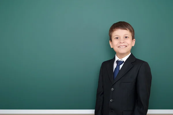 Happy successfull school boy in black suit portrait on green chalkboard background, education concept — Stock Photo, Image