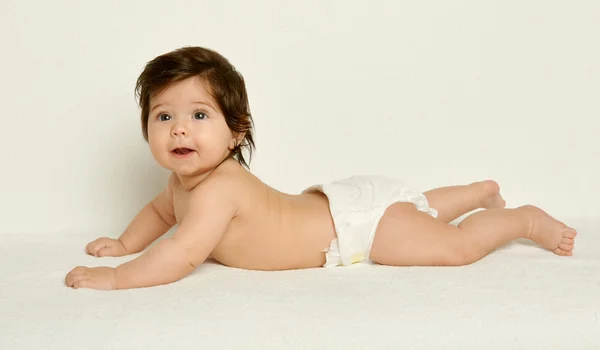 Baby portrait in diaper on white towel at studio, yellow toned — Stock Photo, Image