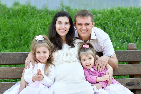 Família ao ar livre, mulher grávida com criança e homem, parque da cidade, temporada de verão, grama verde e árvores — Fotografia de Stock