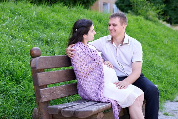 Těhotné ženě a manžel na venkovní, šťastná rodina, pár v městském parku, letní sezóny, zelené trávy a stromů — Stock fotografie