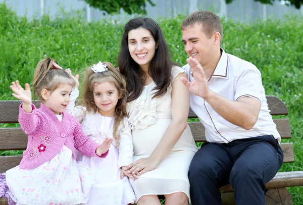 Família ao ar livre, mulher grávida com criança e homem, parque da cidade, temporada de verão, grama verde e árvores — Fotografia de Stock