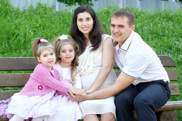 Família ao ar livre, mulher grávida com criança e homem, parque da cidade, temporada de verão, grama verde e árvores — Fotografia de Stock