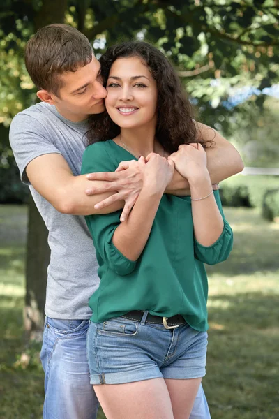 Романтическая пара позирует в городском парке, летний сезон, влюбленные мальчик и девочка — стоковое фото