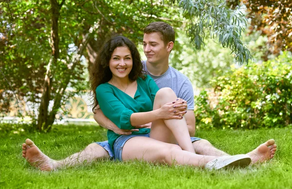 Casal romântico sentar na grama no parque da cidade, temporada de verão, amantes menino e menina — Fotografia de Stock