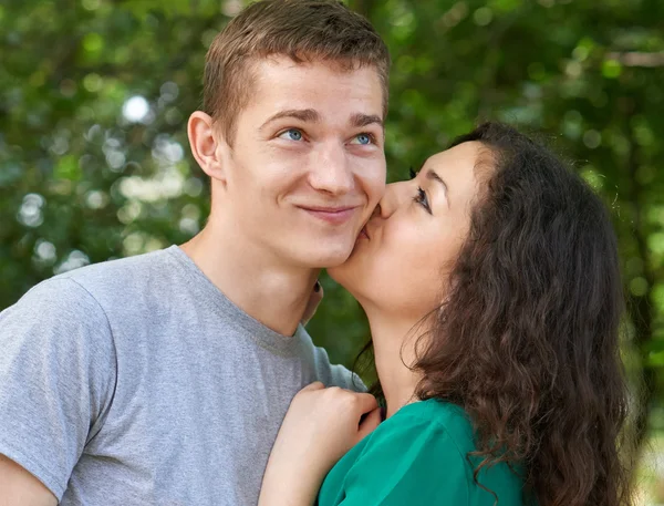 Romantico ritratto di coppia in posa nel parco della città, ragazza che bacia un ragazzo, emozione felice, stagione estiva, amanti ragazzo e ragazza — Foto Stock