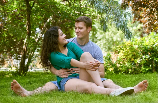 Casal romântico sentar na grama no parque da cidade, temporada de verão, amantes menino e menina — Fotografia de Stock