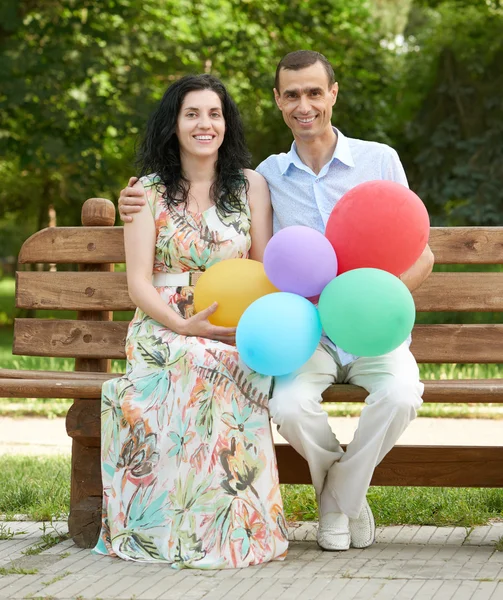 Šťastný romantický pár sedí na lavičce v městském parku a pózování, letní sezóny, dospělých lidí muž a žena — Stock fotografie