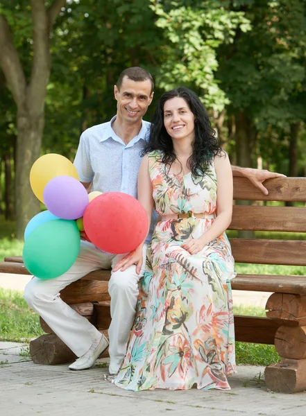 Happy romantic couple sit on bench in city park and posing, summer season, adult people man and woman — Stock Photo, Image