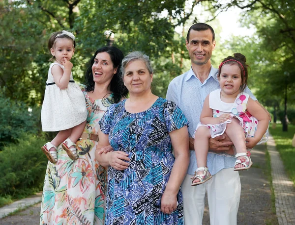 Rodinný portrét v létě městský park, rodiče s dítětem a babička, letní sezóny, zelené trávy a stromů — Stock fotografie