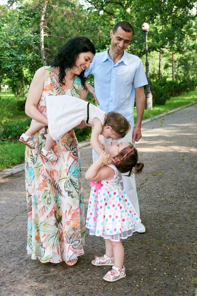 Rodinný portrét v létě městský park, rodiče s dítětem, letní sezóny, zelené trávy a stromů — Stock fotografie