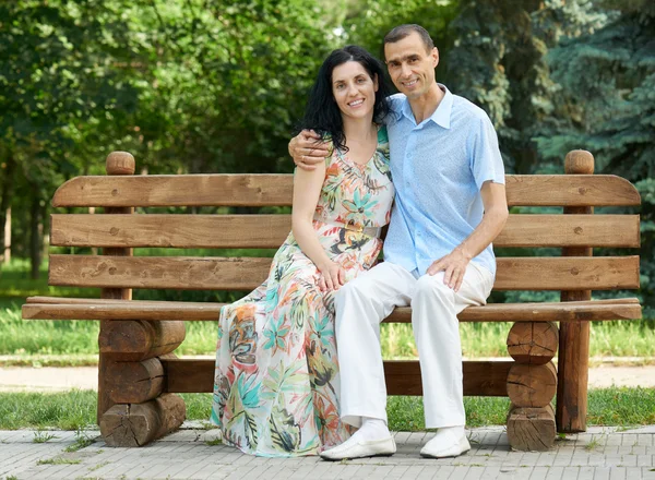 Romantische paar zitten op bankje in stadspark, zomerseizoen, volwassen gelukkige mensen man en vrouw — Stockfoto