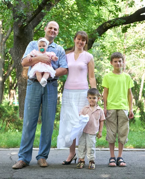 Retrato de família feliz ao ar livre, grupo de cinco pessoas posando no parque da cidade, temporada de verão, criança e pai — Fotografia de Stock
