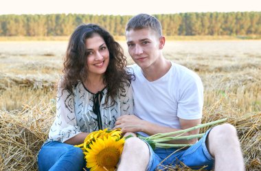 mutlu genç çift buğday alanında oturup akşam, romantik insanlar kavramı, güzel manzara, yaz sezonu